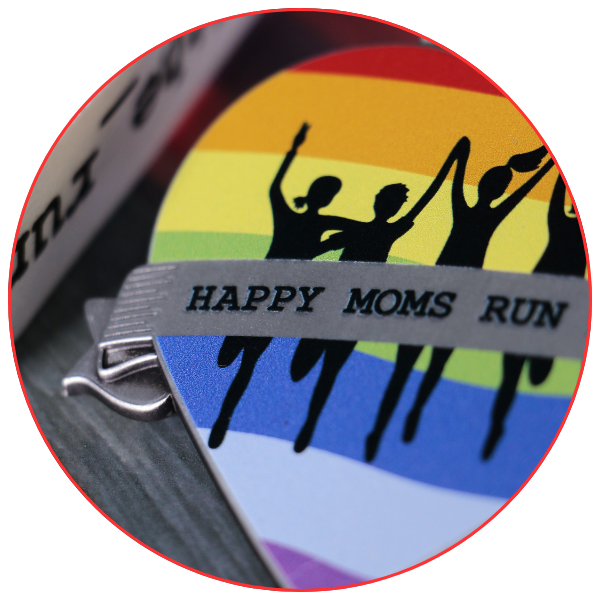 Rainbow-coloured medal for the Happy Moms Run event, featuring silhouettes of running figures.