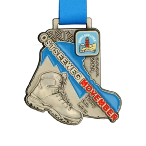 A custom-designed hiking medal for the Ostseeweg event, featuring a boot and lighthouse engraving.