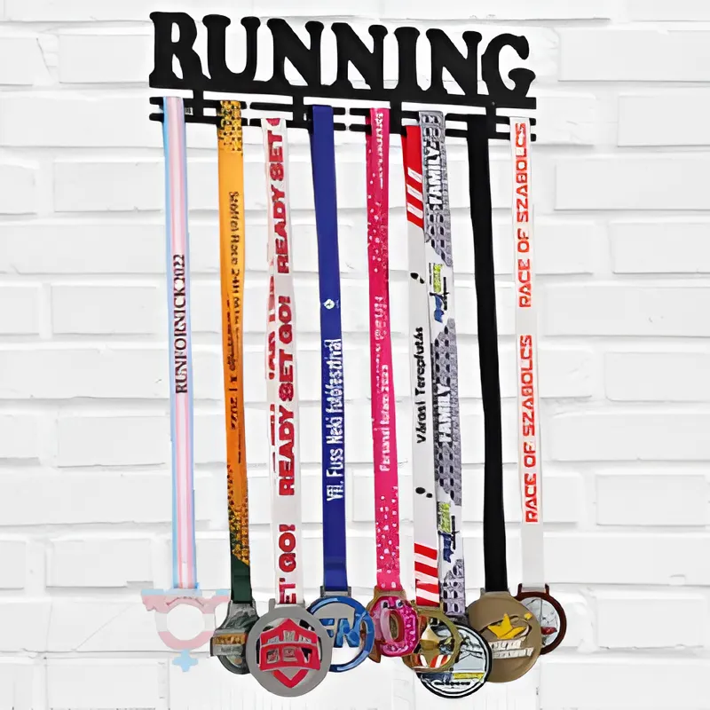 A black medal hanger with the word 'RUNNING', holding colourful lanyards and medals displayed against a white brick wall.